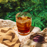 Sunset in Sardinia cocktail with lemongrass-ginger-lemon syrup, coconut water, turmeric-ginger bitters, and a lemongrass salt rim